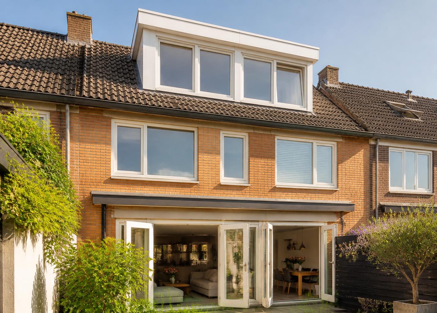 Achtergevel van een woning met een nieuwe lichte houten dakkapel op het dak